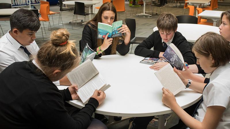 high school pupils reading in school library