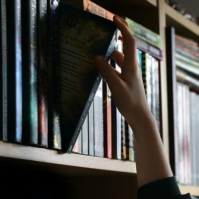 Hand pulling a book off a shelf