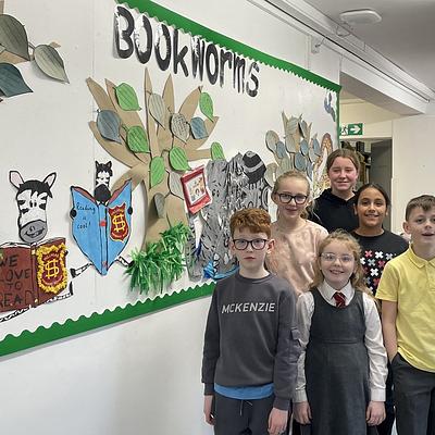 School pupils standing in front of a 'book worms' display