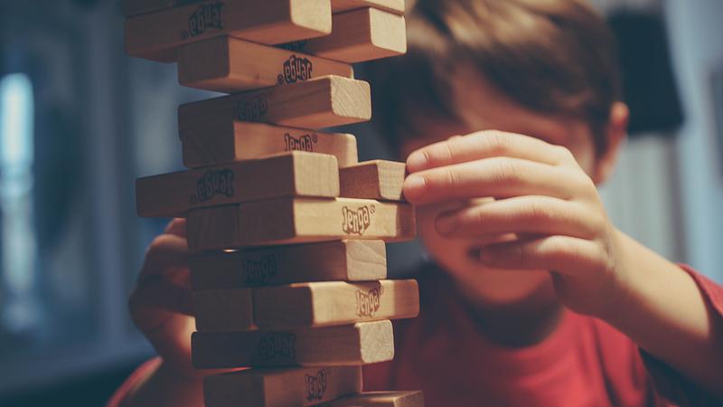 boy playing Book Jenga