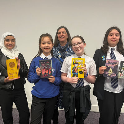 Four smiling student presenters holding books and a colourful trophy alongside Andrea Cooke, LRC Co-ordinator.
