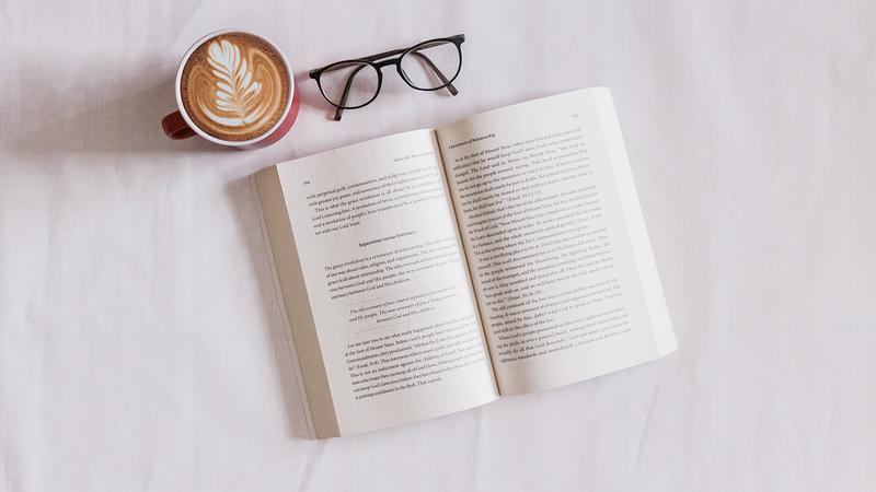 Flat lay of book, spectacles, and coffee mug